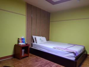 1 dormitorio con cama y mesita de noche en Plus Motel en Gwangju