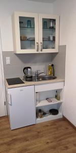 a small kitchen with a sink and a refrigerator at SleepCentral in Düsseldorf