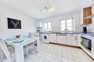 una cocina blanca con una mesa blanca y un mostrador blanco en Wunderschöne Maisonette-Wohnung für bis zu 10 Personen, en Ettenheim 7 fotos más