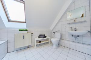 a white bathroom with a toilet and a sink at Wunderschöne Maisonette-Wohnung für bis zu 10 Personen in Ettenheim
