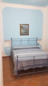 1 cama en un dormitorio con una pared azul en Villa Lina, en Vulcano