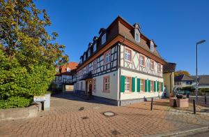 um edifício antigo numa rua de tijolos com uma árvore em Wunderschöne Maisonette-Wohnung für bis zu 10 Personen em Ettenheim