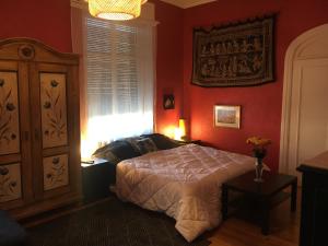 una camera da letto con pareti rosse, un letto e una finestra di Chambres Privatives Chez l'Habitant a Guebwiller