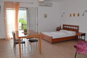 una camera da letto con un letto, un tavolo, un tavolo e delle sedie di Maistrali a Vassiliki