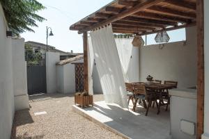 a patio with a wooden table and a wooden pergola at Casa Clementa in Pula