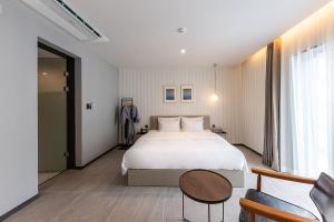 um quarto de hotel com uma cama grande e uma mesa em Brown-Dot Hotel Dongchon Amusement Park em Daegu