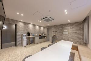 a room with a white table and a brick wall at Brown-Dot Hotel Dongchon Amusement Park in Daegu
