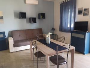 a living room with a table and chairs and a couch at Villa Magie del Mare in Arenella