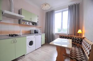 a kitchen with a washing machine and a table at Castle View Apartment in Narva