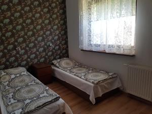 a bedroom with two beds and a window with curtains at Wigwam Apartament 6-osobowy in Sopot