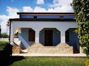 a white house with blue doors and a yard at Villa Magie del Mare in Arenella