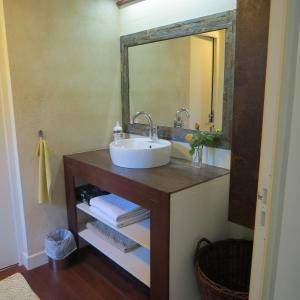 W łazience znajduje się umywalka i lustro. w obiekcie La Belle Insulaire à Vert Bois w mieście Dolus d'Oléron
