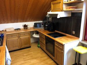 a kitchen with wooden cabinets and a stove top oven at Natürlicher Holzkomfort im hessischen Kegelspiel in Hünfeld