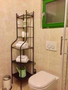 a bathroom with a toilet and a rack with towels at Villa Dule in Pakoštane