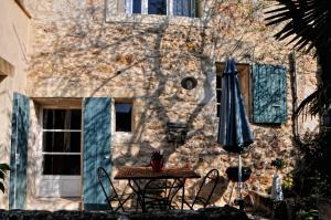 a table and an umbrella in front of a building at La Voûte de Lapparan in Saint-Drézéry