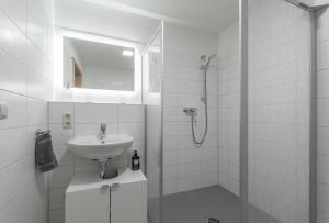 een witte badkamer met een wastafel en een douche bij Perle der Südvorstadt in Leipzig +25 foto's