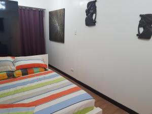 - une chambre avec un lit et des peintures murales dans l'établissement Cucun's place, à Manille