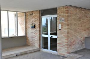 una entrada a un edificio de ladrillo con puertas de cristal en I Tre Fiori, en Matera