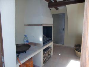 a kitchen with a sink and a fire place at Cases dels Gasulla in Chiva de Morella +127 photos