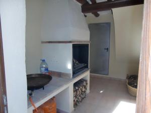 a kitchen with a sink and a fire place at Cases dels Gasulla in Chiva de Morella