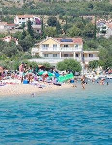 un grupo de personas en una playa cerca del agua en Sunce apartments en Grebaštica