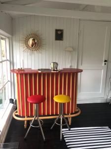 a bar with three stools in a room with a counter at Holldiay house near the beach in Yderby