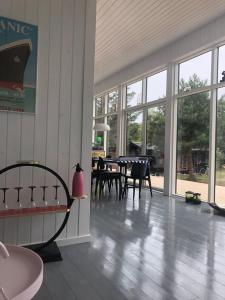 a room with a table and chairs and windows at Holldiay house near the beach in Yderby