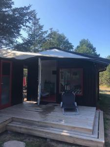 ein schwarzes Zelt mit einem Stuhl auf einer Holzterrasse in der Unterkunft Holldiay house near the beach in Yderby