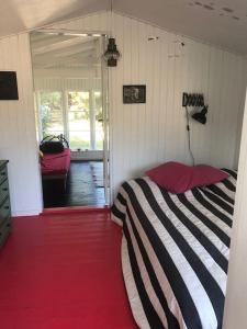 a bedroom with a black and white bed and a door at Holldiay house near the beach in Yderby