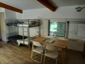 une chambre avec une table, des chaises et des lits superposés dans l'établissement MARTIN's COTTAGE Tourrettes, à Tourrettes