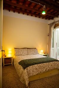 a bedroom with a bed and a window and two lamps at La Casa di Enea in Pistoia