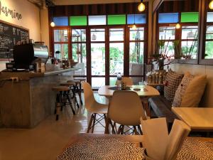 a restaurant with tables and chairs and a bar at Little Jasmine by the River in Phitsanulok