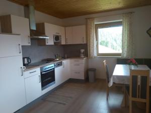 a kitchen with white cabinets and a table and a window at Haus am Sonnenberg in Liesing