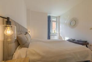 een witte slaapkamer met een groot bed en een raam bij Perle der Südvorstadt in Leipzig