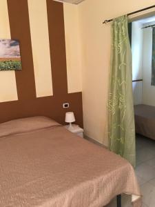 a bedroom with a bed and a green curtain at B&B Baia dello Stretto in Gallico Marina