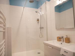 a white bathroom with a shower and a sink at Appartement écologique - Proche Métro Charpennes in Villeurbanne