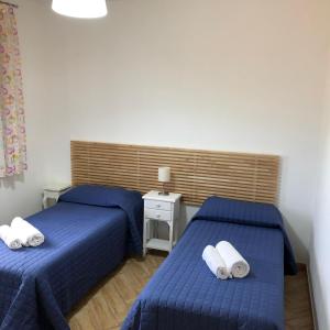 two beds in a room with blue sheets at Casa Giulia in Niscemi