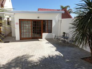 a patio with a table and chairs in front of a house at Pongola Road Self Catering Accommodation in Uitenhage