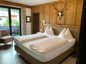 a bedroom with a large bed with a antelope head on the wall at Pension Jaga Hias in Kaprun