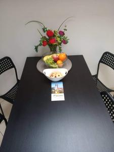 un tavolo nero con un cesto di frutta e un vaso di fiori di Ubytování Žižkova Pacov a Pacov