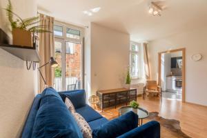 een woonkamer met een blauwe bank en een tafel bij Perle der Südvorstadt in Leipzig