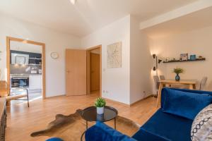 een woonkamer met een blauwe bank en een tafel bij Perle der Südvorstadt in Leipzig