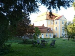 a house with a table and chairs in the grass at Jagdschloss Quitzin in Grimmen