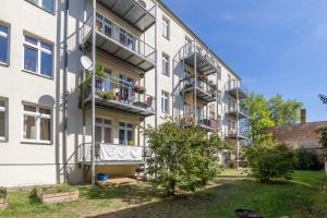 an apartment building with balconies and a yard at Perle der Südvorstadt in Leipzig