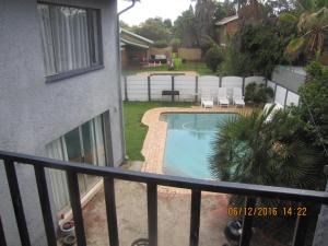 a balcony of a house with a swimming pool at Airport Leisure Lodge in Kempton Park
