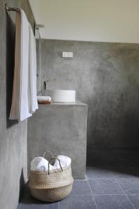 a bathroom with a sink and a basket at Ambarella Lodge - Katunayake in Hunumulla