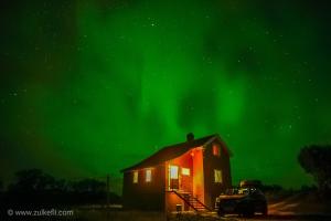 a house with the green northern lights above it at Bogstrand, Dverbergveien 11, 8485 Dverberg in Dverberg