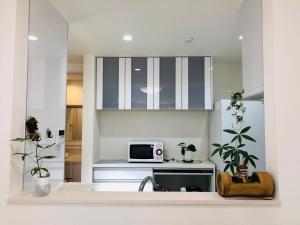 a kitchen with a sink and a microwave at Takara House in Tokyo