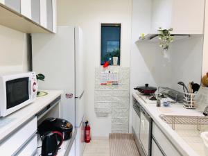 a kitchen with white cabinets and a counter top at Takara House in Tokyo