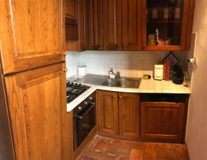 a kitchen with wooden cabinets and a sink at In centro in Montalcino